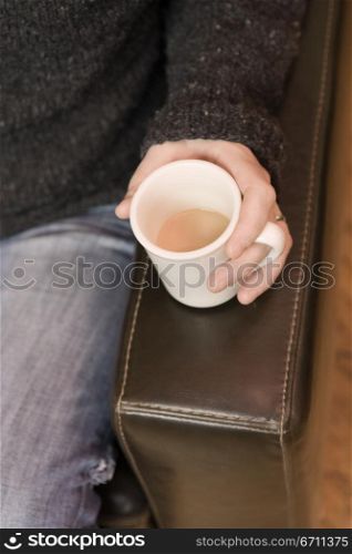 Close up of a hand holding a mug