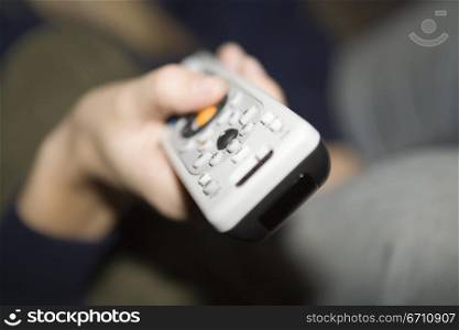 Close up of a hand holding a remote control