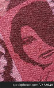 Close-up of a human face knitted on a woolen fabric