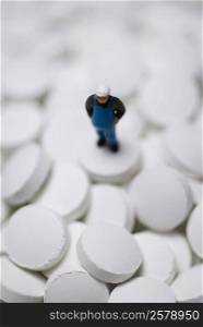 Close-up of a human figurine on the heap of pills