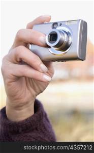 Close-up of a human hand photographing with a digital camera