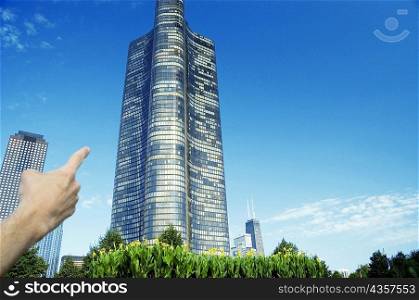 Close-up of a human hand pointing to a building, Lake Point Tower, Chicago, Illinois, USA