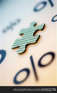 Close-up of a jigsaw piece and a percentage sign