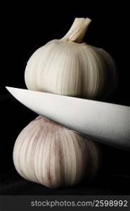 Close-up of a knife cutting garlic