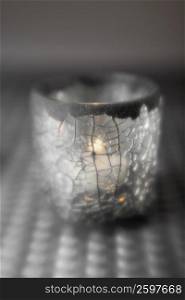 Close-up of a lit candle in a glass