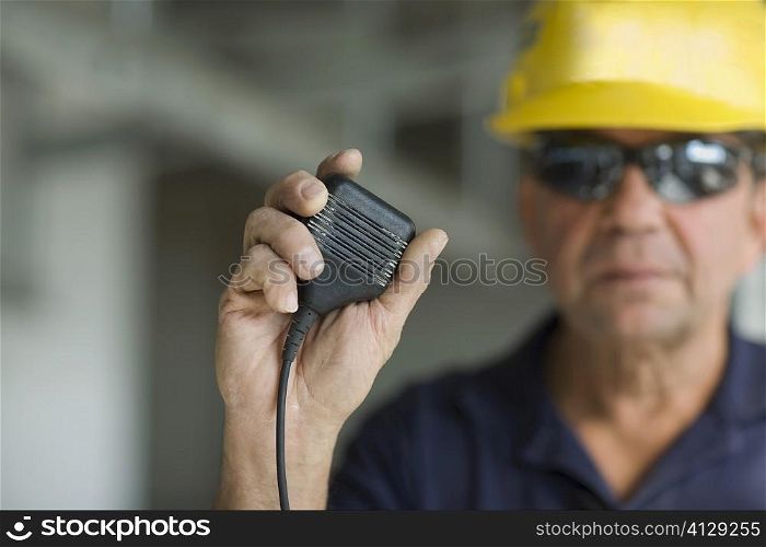 Close-up of a male construction worker holding a CB radio