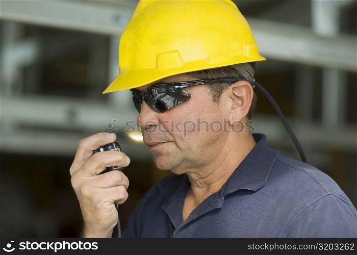 Close-up of a male construction worker talking on a CB radio