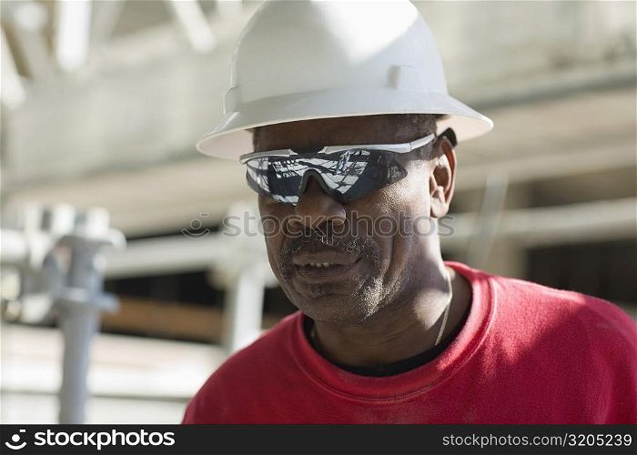 Close-up of a male construction worker with a hardhat and a pair of sunglasses