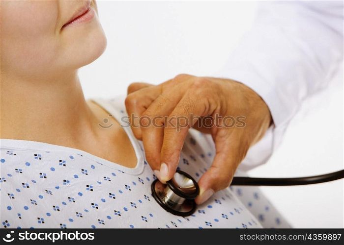 Close-up of a male doctor&acute;s hand examining a female patient with a stethoscope