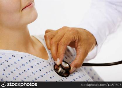 Close-up of a male doctor&acute;s hand examining a female patient with a stethoscope