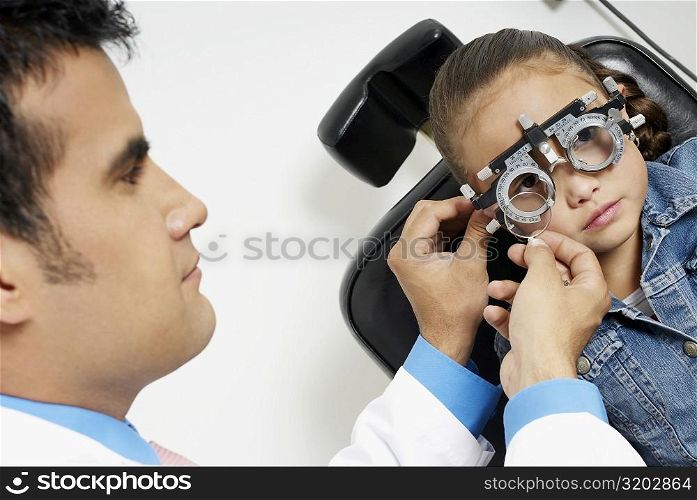 Close-up of a male doctor examining a girl&acute;s eye
