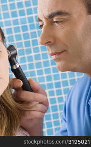 Close-up of a male doctor examining a mature woman&acute;s ear