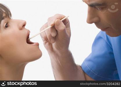 Close-up of a male doctor examining a mature woman&acute;s mouth