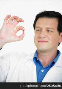 Close-up of a male doctor holding a capsule