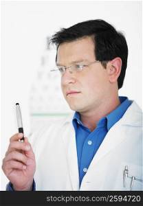 Close-up of a male doctor holding a pen