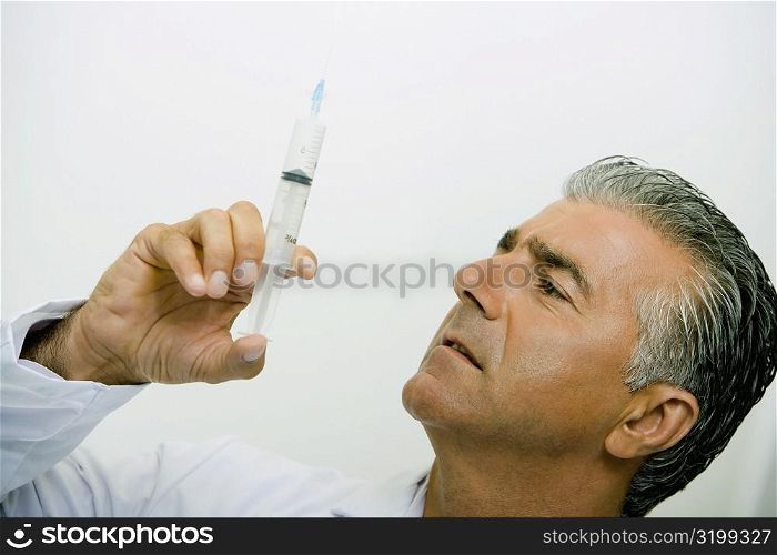 Close-up of a male doctor holding a syringe