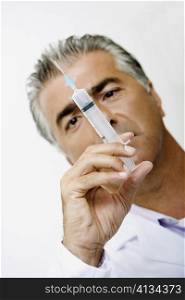 Close-up of a male doctor holding a syringe