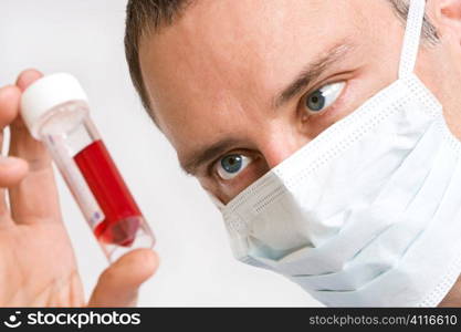 Close up of a male doctor looking at a blood sample