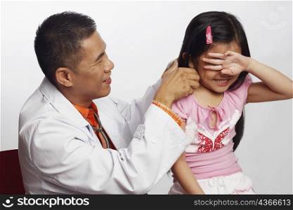 Close-up of a male doctor playing with a girl