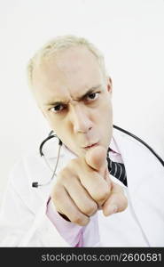 Close-up of a male doctor pointing forward and looking angry