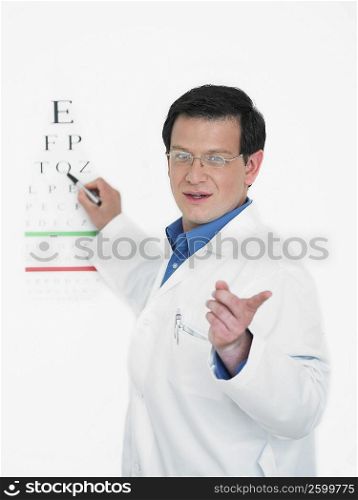 Close-up of a male doctor pointing towards an eye chart