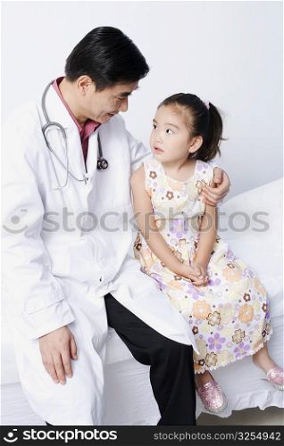 Close-up of a male doctor sitting with a girl