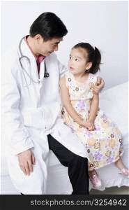 Close-up of a male doctor sitting with a girl