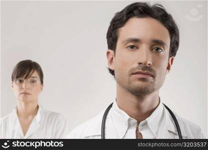Close-up of a male doctor with a female doctor behind him