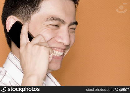 Close-up of a male office worker talking on a mobile phone and smiling