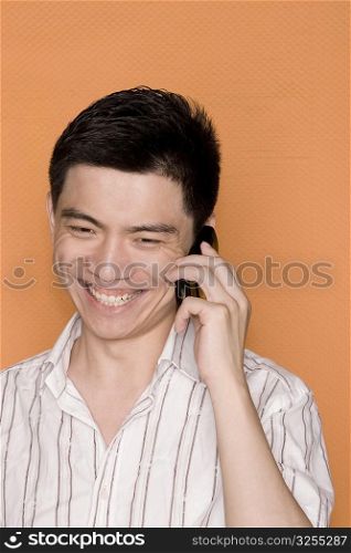 Close-up of a male office worker talking on a mobile phone and smiling