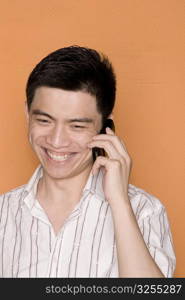 Close-up of a male office worker talking on a mobile phone and smiling