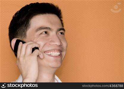 Close-up of a male office worker talking on a mobile phone and smiling