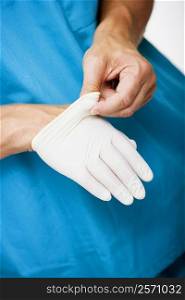 Close-up of a male surgeon&acute;s hand removing a surgical glove from his hand