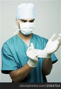 Close-up of a male surgeon putting on surgical gloves