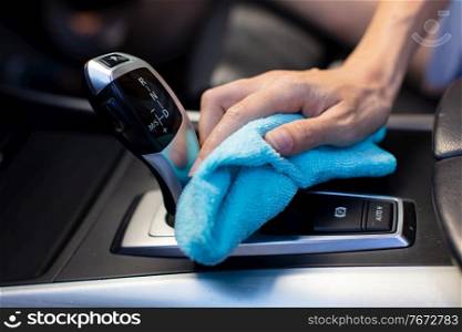 close-up of a male worker cleaning seat inside the car