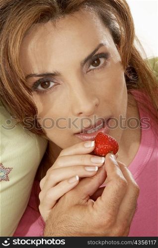Close-up of a man&acute;s hand feeding a mid adult woman a strawberry