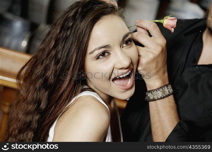 Close-up of a man&acute;s hand fixing a flower in a teenage girl&acute;s hair