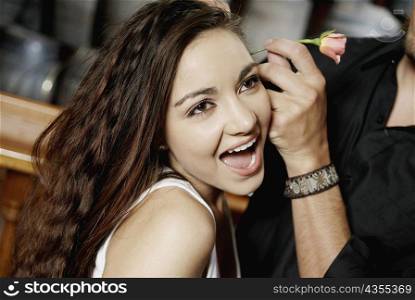 Close-up of a man&acute;s hand fixing a flower in a teenage girl&acute;s hair