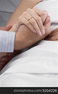 Close-up of a man&acute;s hand holding a female patient&acute;s hand
