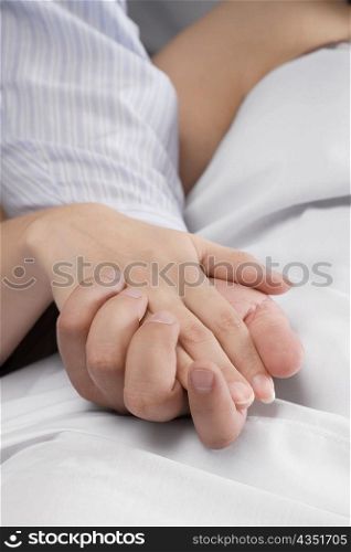 Close-up of a man&acute;s hand holding a female patient&acute;s hand