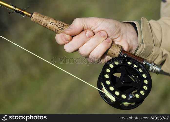 Close-up of a man&acute;s hand holding a fishing rod
