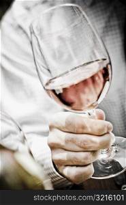 Close-up of a man&acute;s hand holding a glass of red wine