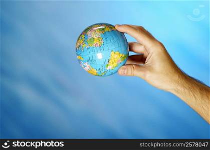 Close-up of a man&acute;s hand holding a globe