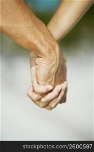 Close-up of a man&acute;s hand holding a woman&acute;s hand