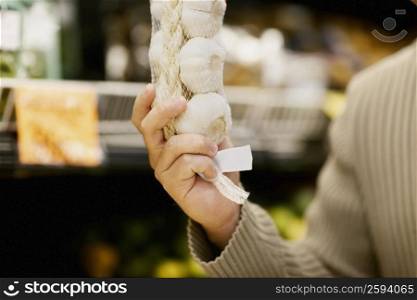 Close-up of a man&acute;s hand holding garlic in a vegetable market