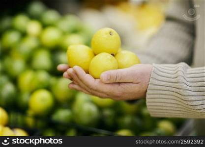 Close-up of a man&acute;s hand holding lemons