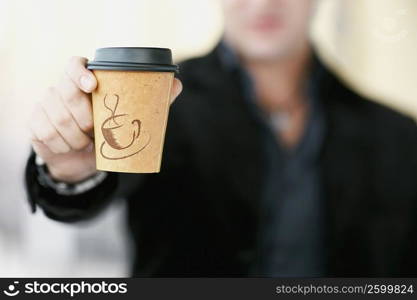 Close-up of a man&acute;s hand showing a coffee cup