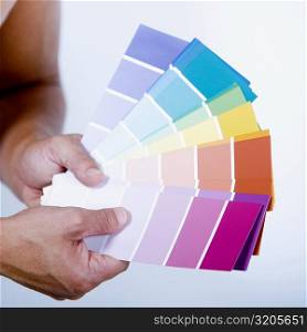 Close-up of a man&acute;s hands holding color swatches