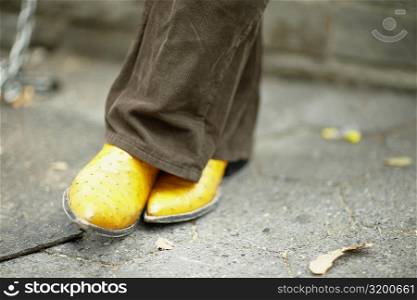 Close-up of a man&acute;s leg wearing yellow shoes