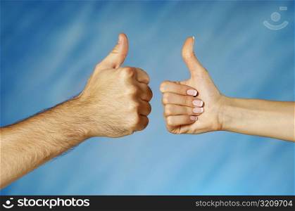Close-up of a man and a woman&acute;s hands making a thumbs up sign